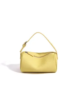 Sac à épaule cylindrique en cuir jaune, sac à main minimaliste pour femme style quotidien.