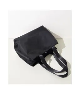 Black nylon tote bag detail view, minimalist large capacity shoulder handbag, durable daily use.