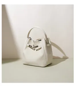 Detailed view of minimal white leather bucket bag showcasing exquisite hardware and stitching.