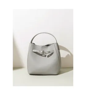 Minimalist grey leather bucket bag with classic metal lock design detail view now.