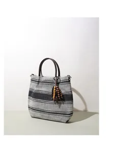 Schwarz-weiße gestreifte Handtasche mit Holzperlen Anhänger und dunklen kurzen Griffen.