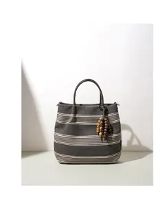 Detailansicht der gestreiften Canvas-Handtasche mit ethnischen Holzperlen und stabilen Griffen.