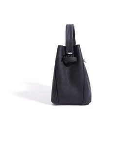 Detailed side view of black genuine leather bucket bag showing fine texture and hardware.