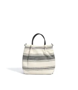 Detailansicht der gestreiften Canvas-Handtasche mit langlebigen Ledergriffen und feiner Webstruktur.