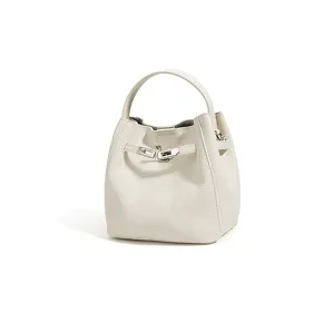 Minimalist leather bucket bag with top handle and metal lock clasp for women commuting daily stylish