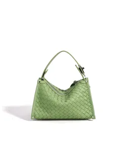 Vue détaillée du sac à main en cuir tissé vert sauge, mettant en valeur sa texture unique.