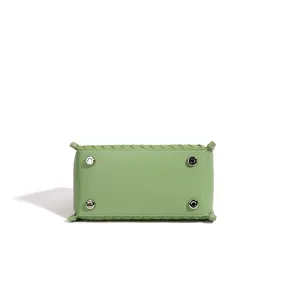 Sac a main en cuir vert clair vue du dessous avec motif tresse et rivets metalliques.