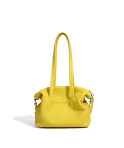 Vista detallada del bolso de cuero amarillo con textura suave y cierre de cremallera seguro.