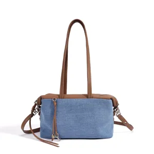 Sac épaule en denim et cuir détail, panneaux contrastés, charm clé en métal, élégant.
