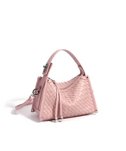 Vue détaillée du sac à main tressé en cuir rose, texture intrecciato délicate et accessoires métal.