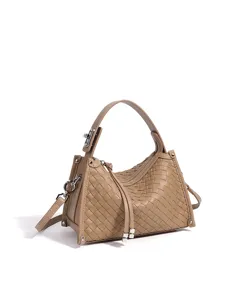 Détail de la pochette en cuir tressé avec un motif élégant et des finitions en métal brillant et soigné.