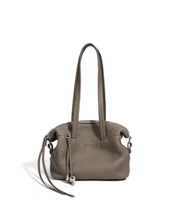 Detalle de un elegante bolso de hombro para mujer de cuero genuino con bonito colgante.