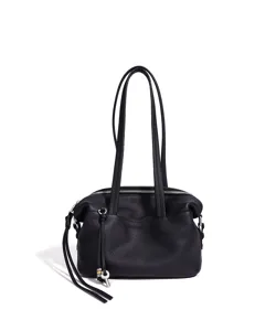 Vista detallada del elegante bolso de hombro de cuero negro con cremallera y llavero.
