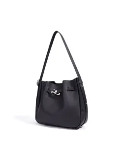 Vista detallada del bolso tipo cubo de cuero negro con herrajes metálicos, diseño elegante.
