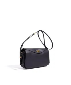 Vue détaillée du sac porté épaule en cuir noir avec finitions dorées et fermoir chic.