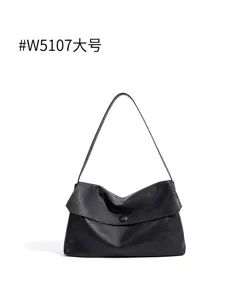 Detail shot of the black leather shoulder bag showing soft texture and premium craftsmanship.