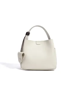 Detailed view of the elegant minimalist white bucket bag with a stylish handle knot.