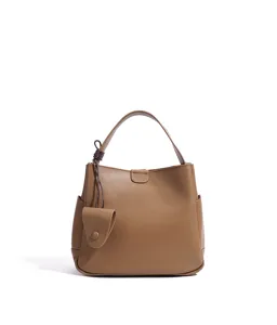 Brown leather bucket bag detail showing minimalist handle and cute charm design for daily commute.