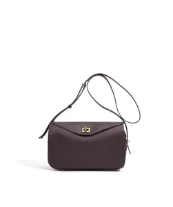 Sac à bandoulière minimaliste en cuir marron foncé avec sangle réglable et fermoir métallique.