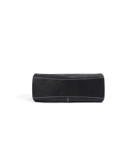Vue détaillée du fond d'un sac à main noir en cuir élégant avec de jolies surpiqûres blanches.