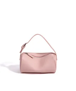 Vue détaillée du sac cylindrique en cuir rose, montrant une texture fine et une fermeture.