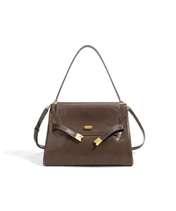 Sac à bandoulière en cuir marron pour femmes, élégant sac à main avec boucle métallique.