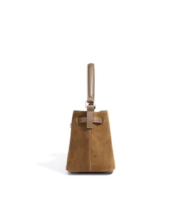 Brown suede bucket bag detail view, retro top handle handbag with stylish belt strap design.