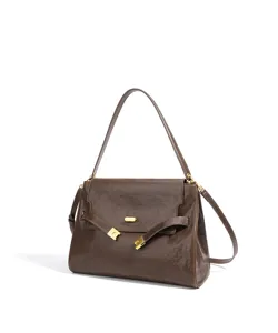 Gros plan détaillé du sac à main en cuir marron foncé avec de superbes finitions dorées.