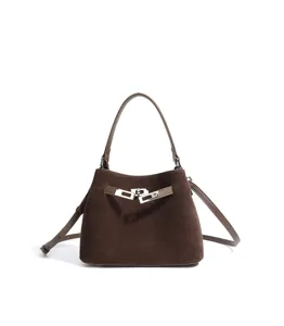 Brown suede top handle bag featuring a classic turn-lock closure and versatile crossbody strap.