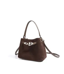 Brown suede handbag detail featuring metallic turn-lock closure and shoulder strap.