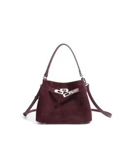 Wine red suede bucket bag with metallic lock closure, elegant top handle and crossbody strap.