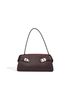 Detailaufnahme der dunklen Leder-Schultertasche mit stilvollem Metallverschluss und rotem Futter.