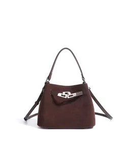 Detailed view of brown suede bucket bag with metal lock closure and classic design structure.
