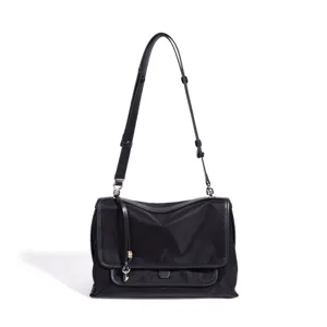 Bolso bandolera de nailon negro minimalista con solapa para el trayecto diario.