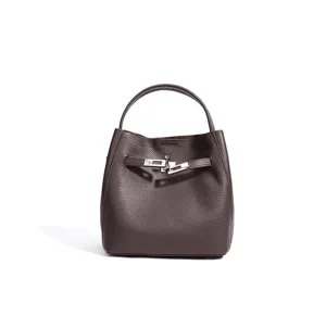 Detailed view of brown leather bucket bag with metal lock, chic commuting crossbody style.