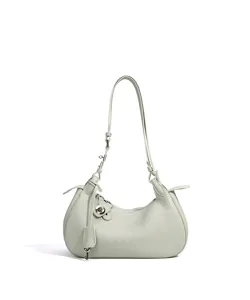 Vue rapprochée du sac porté épaule en cuir vert clair, style hobo minimaliste élégant.