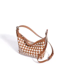 Detailansicht einer schicken braun weißen Flechttasche, elegante Umhängetasche für Damen.