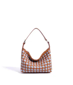 Nahaufnahme der geflochtenen Hobo Schultertasche aus braunem Leder und blauem Stoff im Interieur.