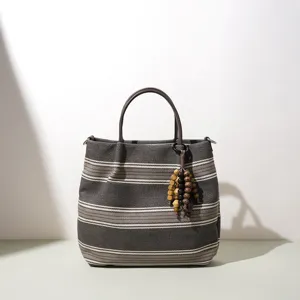 Schicke gestreifte Baumwoll-Leinen Handtasche mit braunen Griffen und Holzperlen Anhänger.