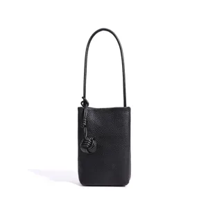 Schwarze Mini-Handytasche aus echtem Leder mit stilvollem Knotengriff und Umhängeband.