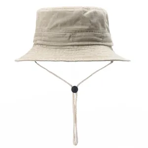 Close-up of khaki washed cotton bucket hat with adjustable chin strap and black toggle detail.