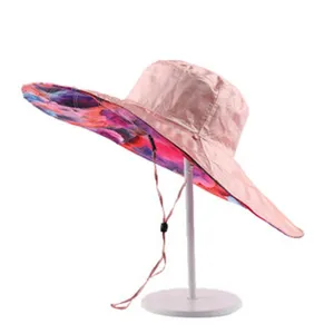 Wide-brim sun hat with colorful artistic print underside and adjustable chin strap for UV protection.