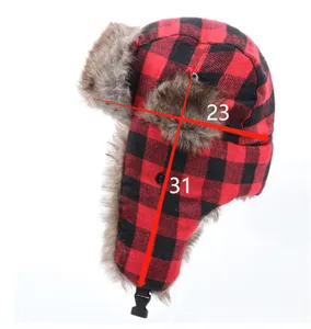 Detailed view of the red and black plaid winter trapper hat, showcasing thick warm earflaps.