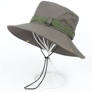 Close-up of a grey outdoor sun hat featuring breathable metal eyelets, green strap, and wind cord.