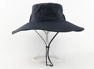 Detail view of navy wide-brim sun hat, featuring adjustable chin strap for outdoor activities.