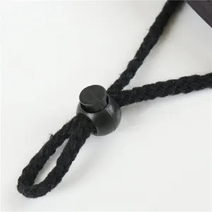 Close-up detail of outdoor sun hat adjustable black drawstring cord lock and braided rope.