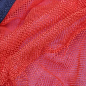 Close-up detail of red breathable mesh fabric for children outdoor sun hats, durable.