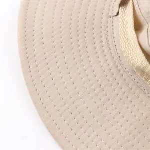 Detailed view of beige cotton bucket hat brim, showing fine stitching and durable fabric quality.