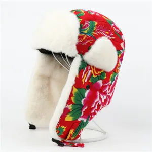 Close-up detail of traditional red floral winter ushanka hat with soft white faux fur lining.