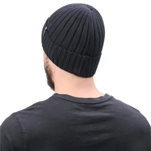 Detail view of men's black knit winter beanie hat with ribbed texture and side label.